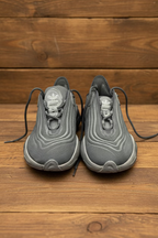 Pair of black sneakers on a wooden surface
